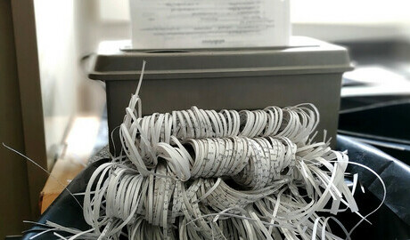 Paper going through a paper shredder.
